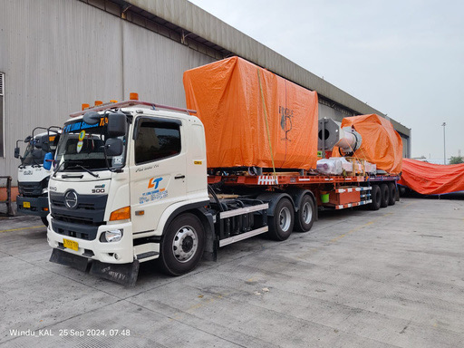 LST truck with oversized cargo under orange tarpaulin